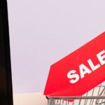 Cyber Monday - A Red Sale Tag on a Miniature Shopping Cart Placed on a Macbook Laptop