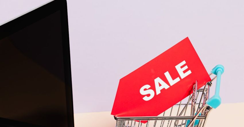 Cyber Monday - A Red Sale Tag on a Miniature Shopping Cart Placed on a Macbook Laptop